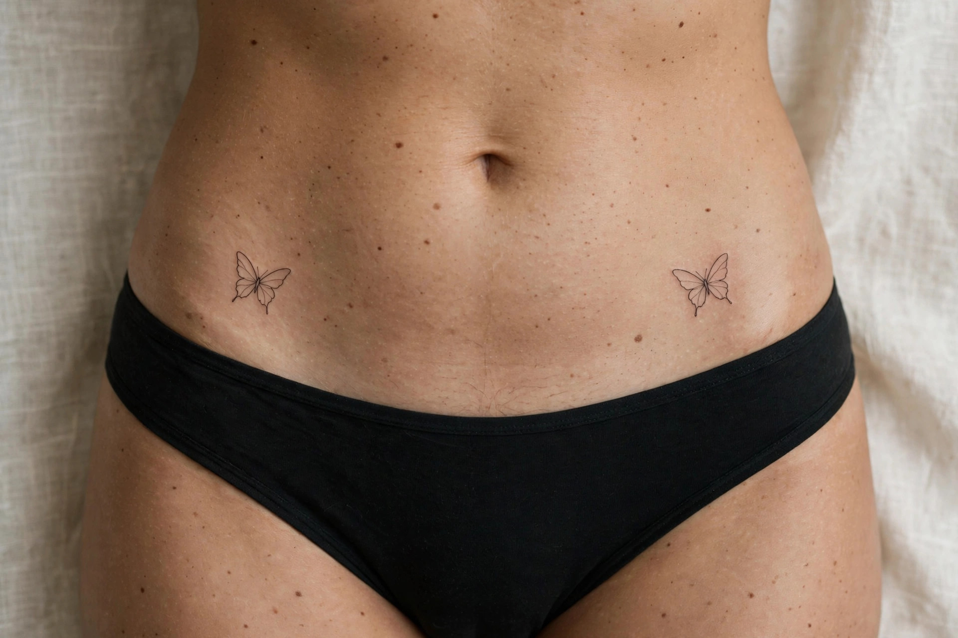 Mirrored minimalist butterfly hip tattoos, symmetrical waist ink