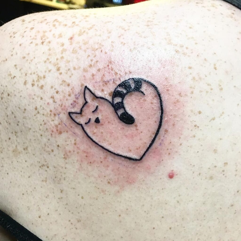 Minimalist Heart Shaped Sleeping Cat Tattoo on shoulder with striped tail forming heart