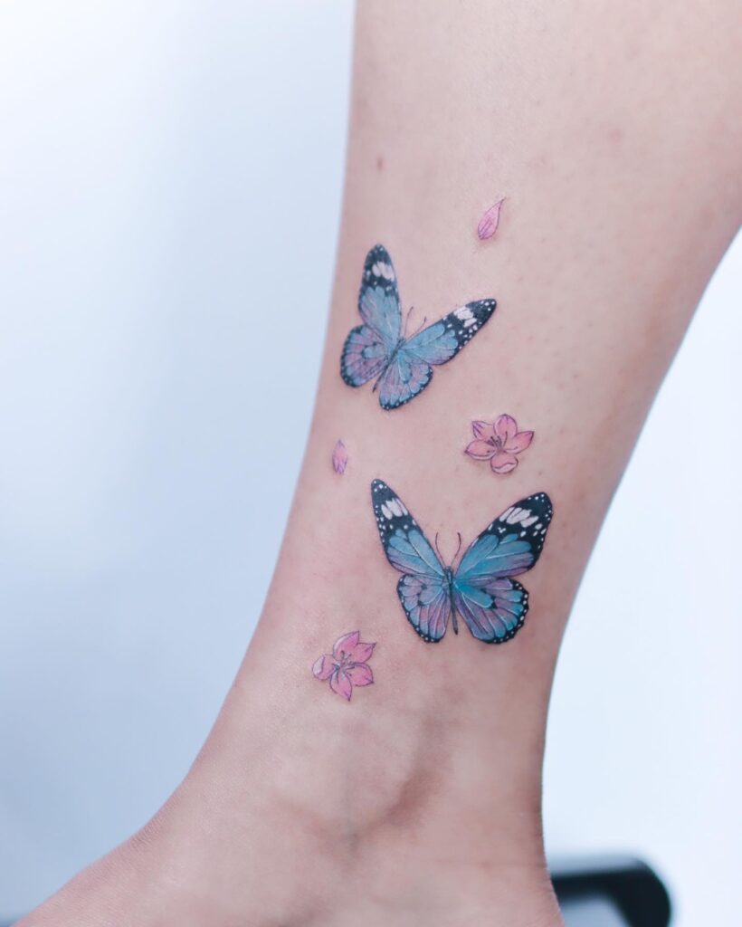 Blue monarch butterfly tattoos with flowers on ankle