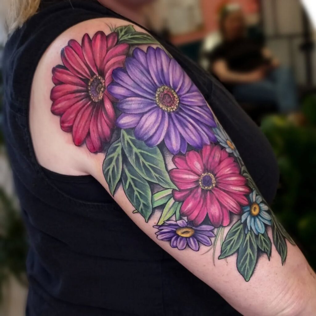 Bold and Colorful Daisy Sleeve Tattoo april birth flower tattoo ideas tattoo