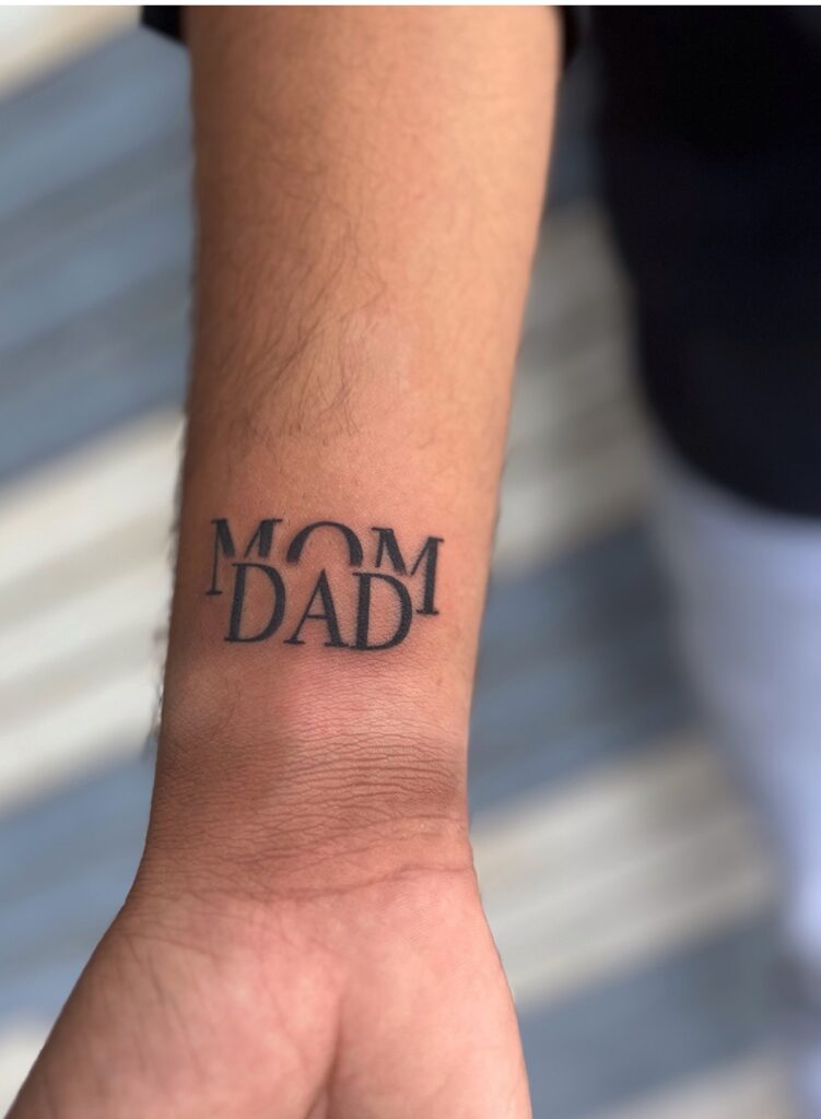 Bold Overlapping Mom Dad Wrist Tattoo mom dad tattoos tattoo