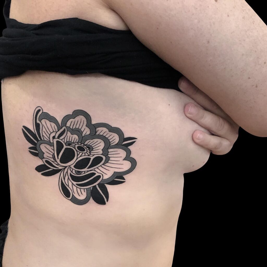 Bold Peony Rib Tattoo in Blackwork japanese peony tattoos tattoo