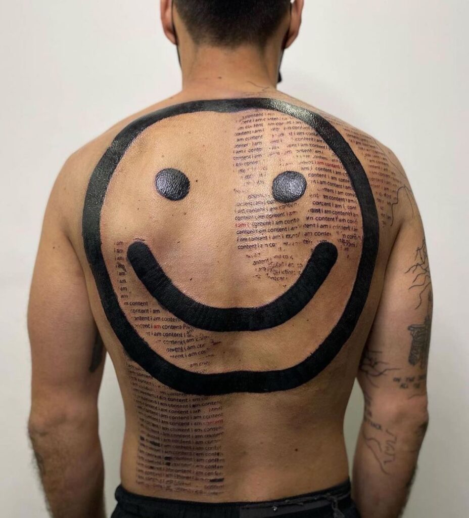 Bold Smiley Face with Repeated Text Back Tattoo back tattoos for guys tattoo