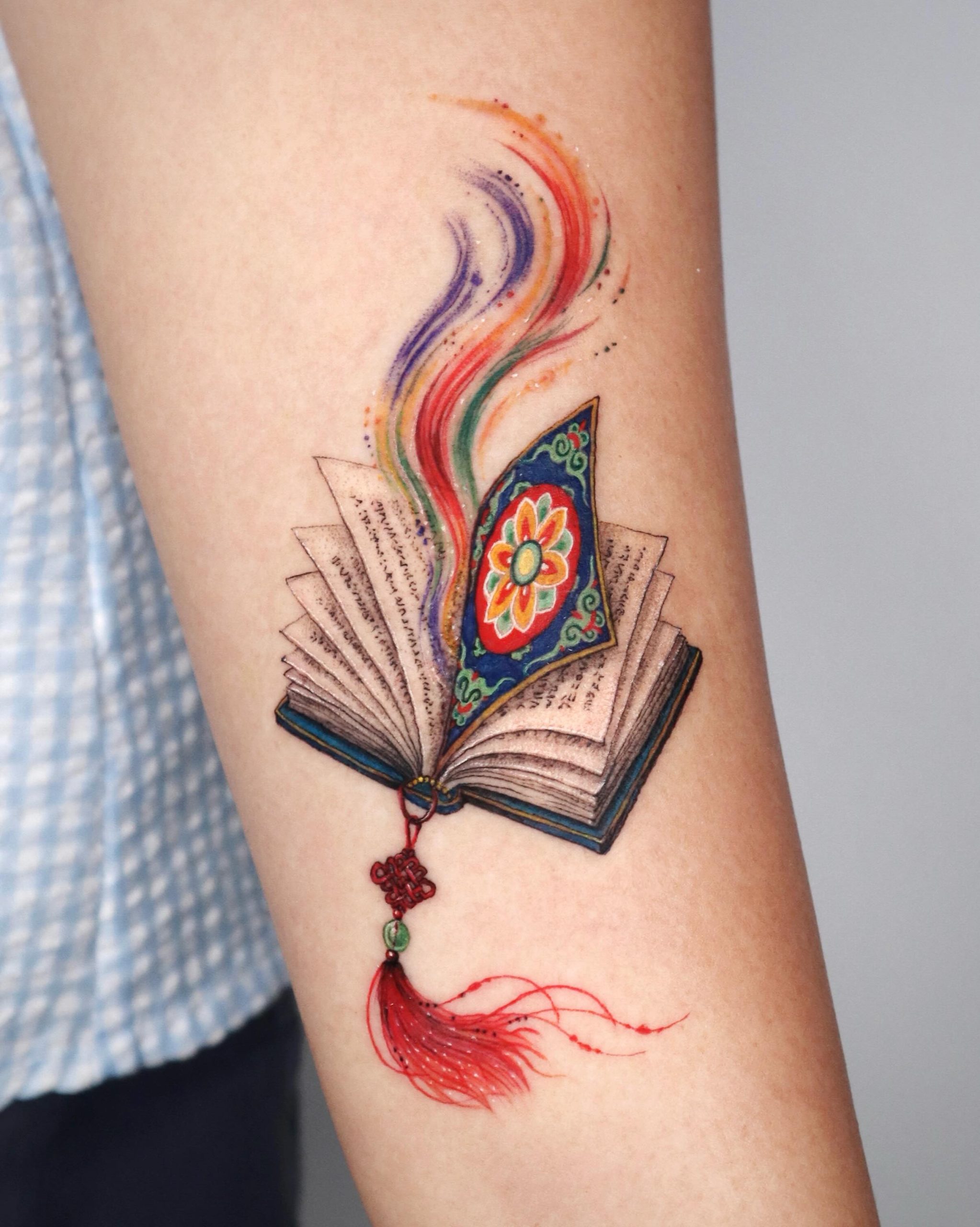 Open Book With Colorful Magic Pages Tattoo