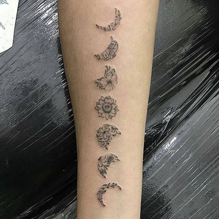 Floral moon phases tattoo with botanical vines
