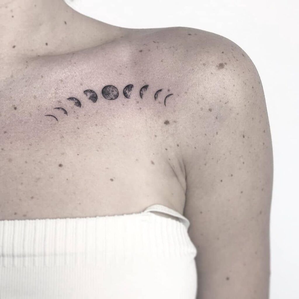 Moon phases tattoo spanning the collarbone