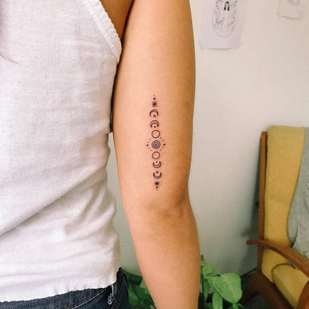 Celestial moon phases arm tattoo with sparkling stars