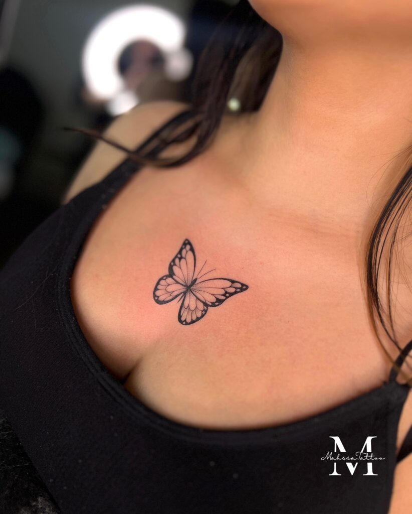 Small butterfly tattoo on the center sternum