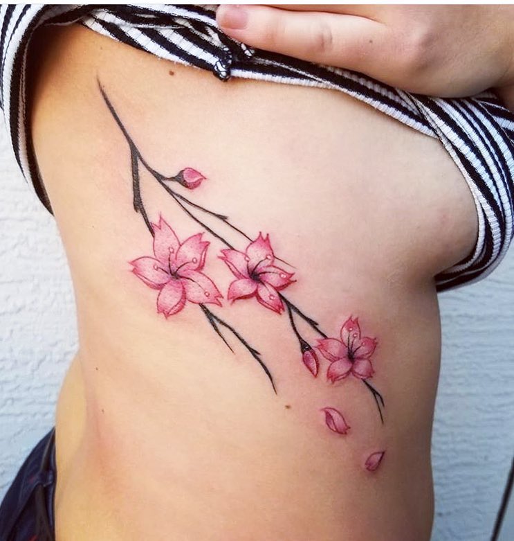 Cherry Blossom Rib Tattoo with Falling Petals cherry blossom tattoo ideas tattoo