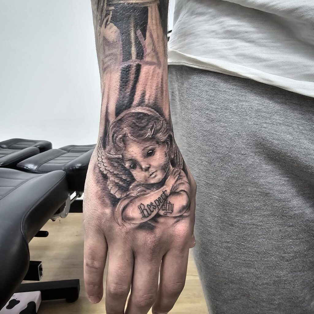Cherubic Hand Tattoo with Script hand tattoo ideas for guys tattoo