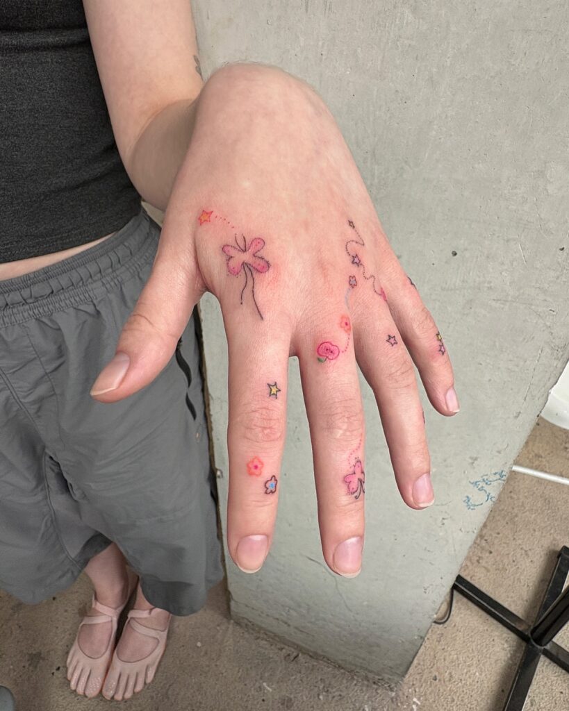 Red Ink Floral And Star Finger Tattoos
