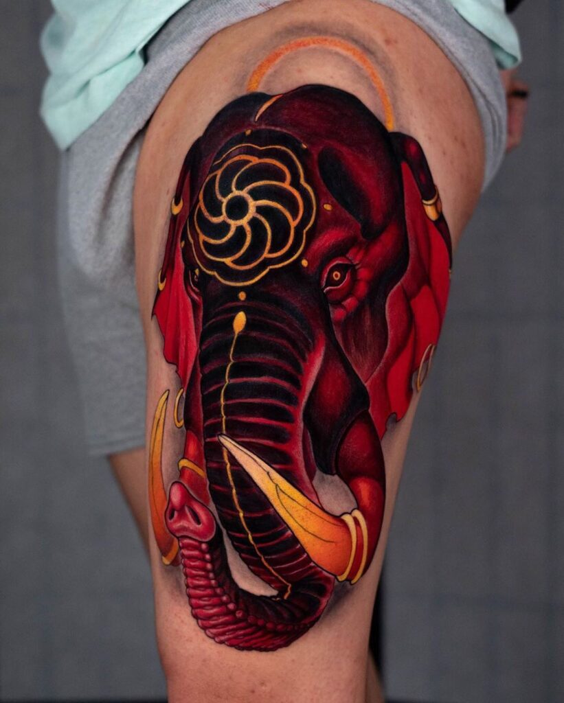 Red ink elephant tattoo with golden accents