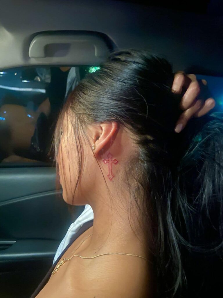 Red ink gothic cross behind the ear