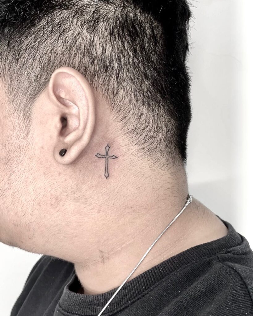 Outlined geometric cross behind the ear