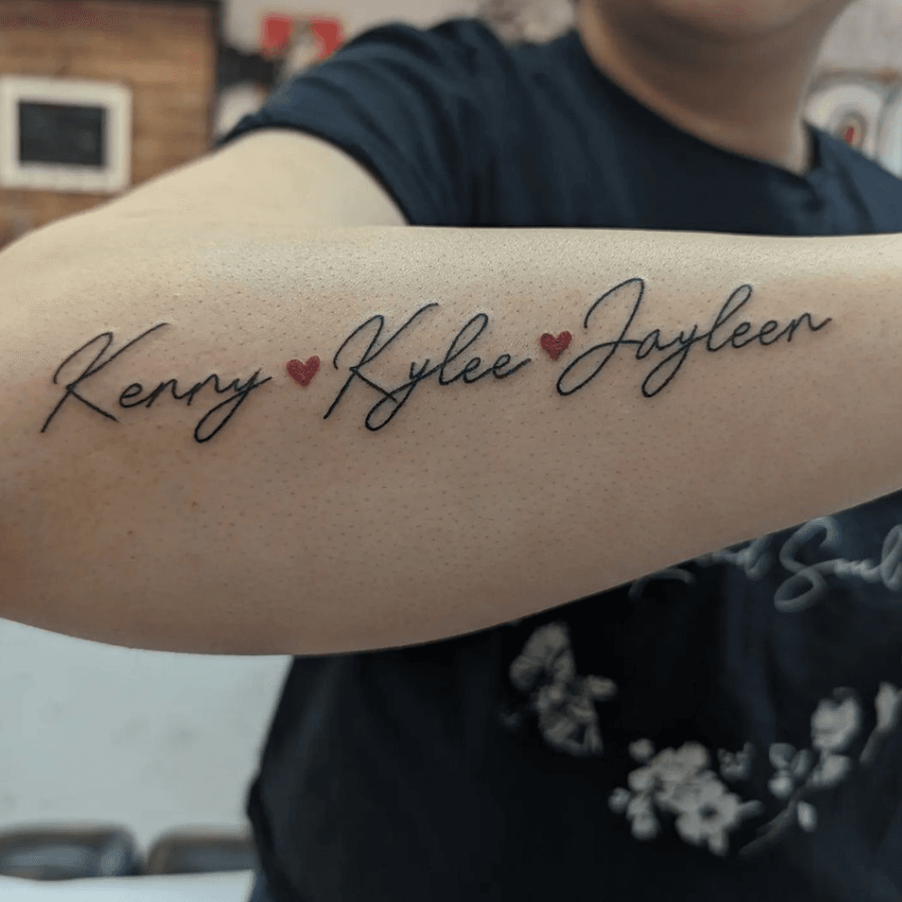 Cursive Sibling Names Linked by Red Heart Dots kids name tattoo