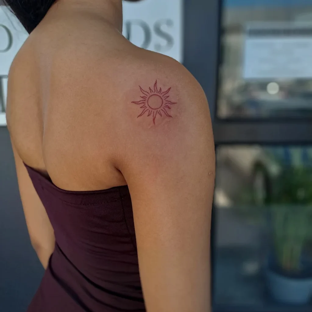 Delicate Red Sun Tattoo on Shoulder sun tattoos tattoo