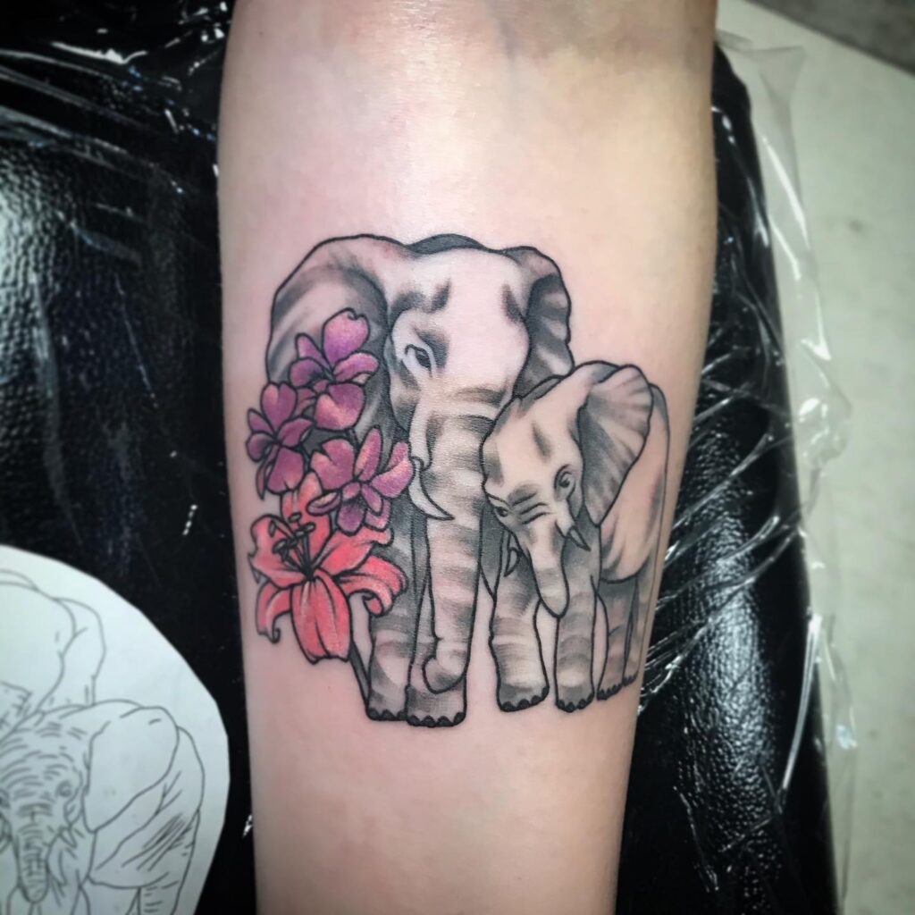 Elephant Duo with Pink Floral Accent Tattoo elephant family tattoo ideas tattoo