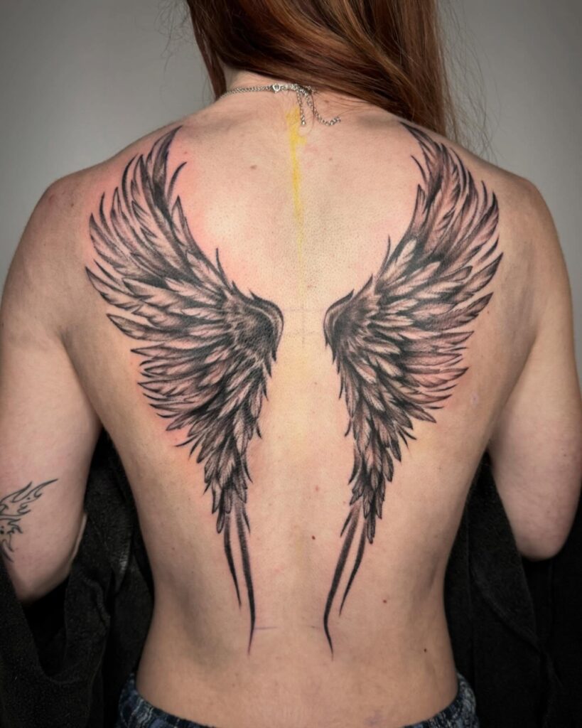 Elongated Angel Wings Tattoo with Bold Feather Lines angel wings tattoo ideas on back tattoo
