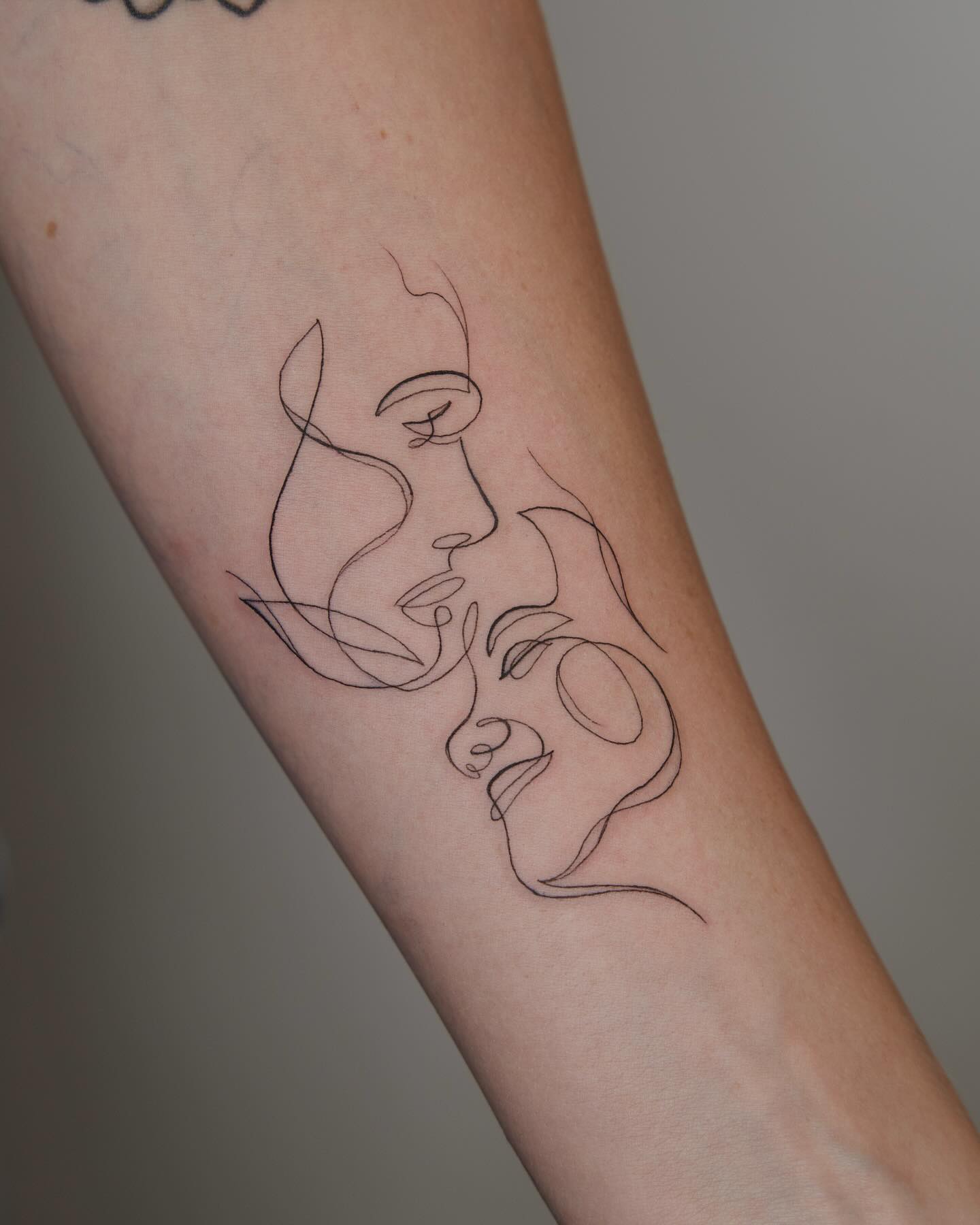 One line couple embrace tattoo on forearm