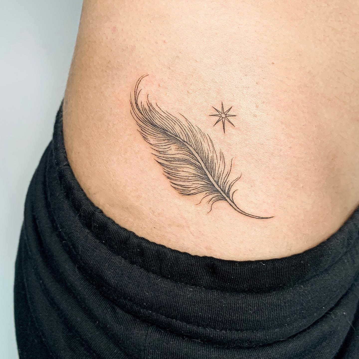 Fine Line Feather And Star Tattoo