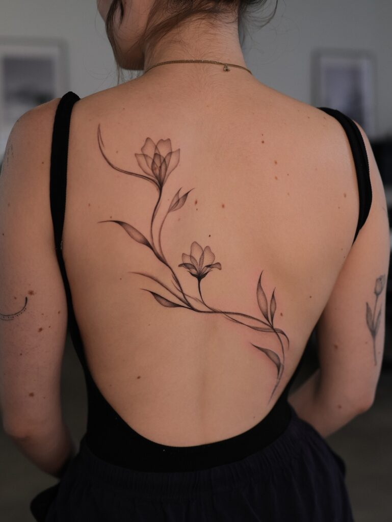 Fine Line Floral Tattoo Flowing Across Back fine line tattoos for women tattoo