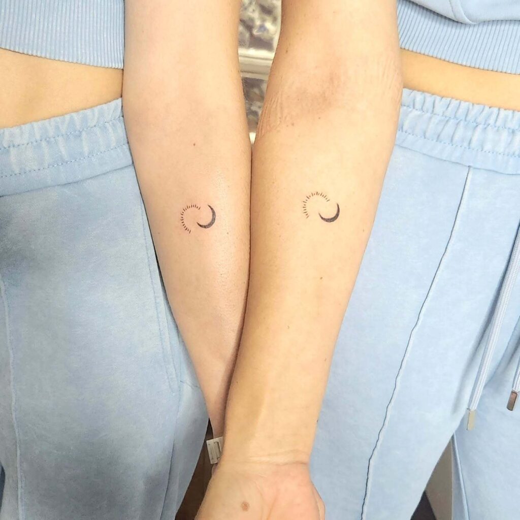 Tiny sun halo and moon tattoos on hand