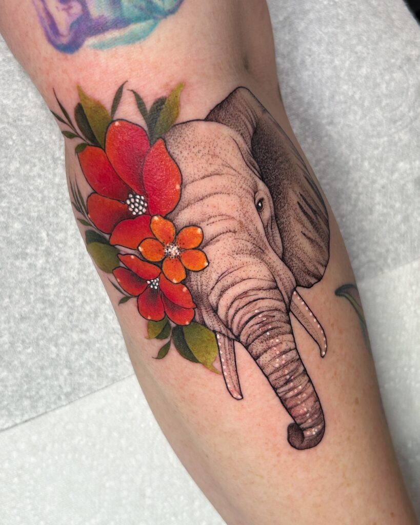 Elephant tattoo with red and orange flowers