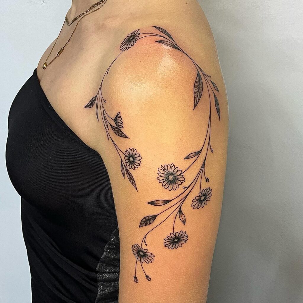 Flowing Daisy Shoulder and Arm Tattoo april birth flower tattoo ideas tattoo