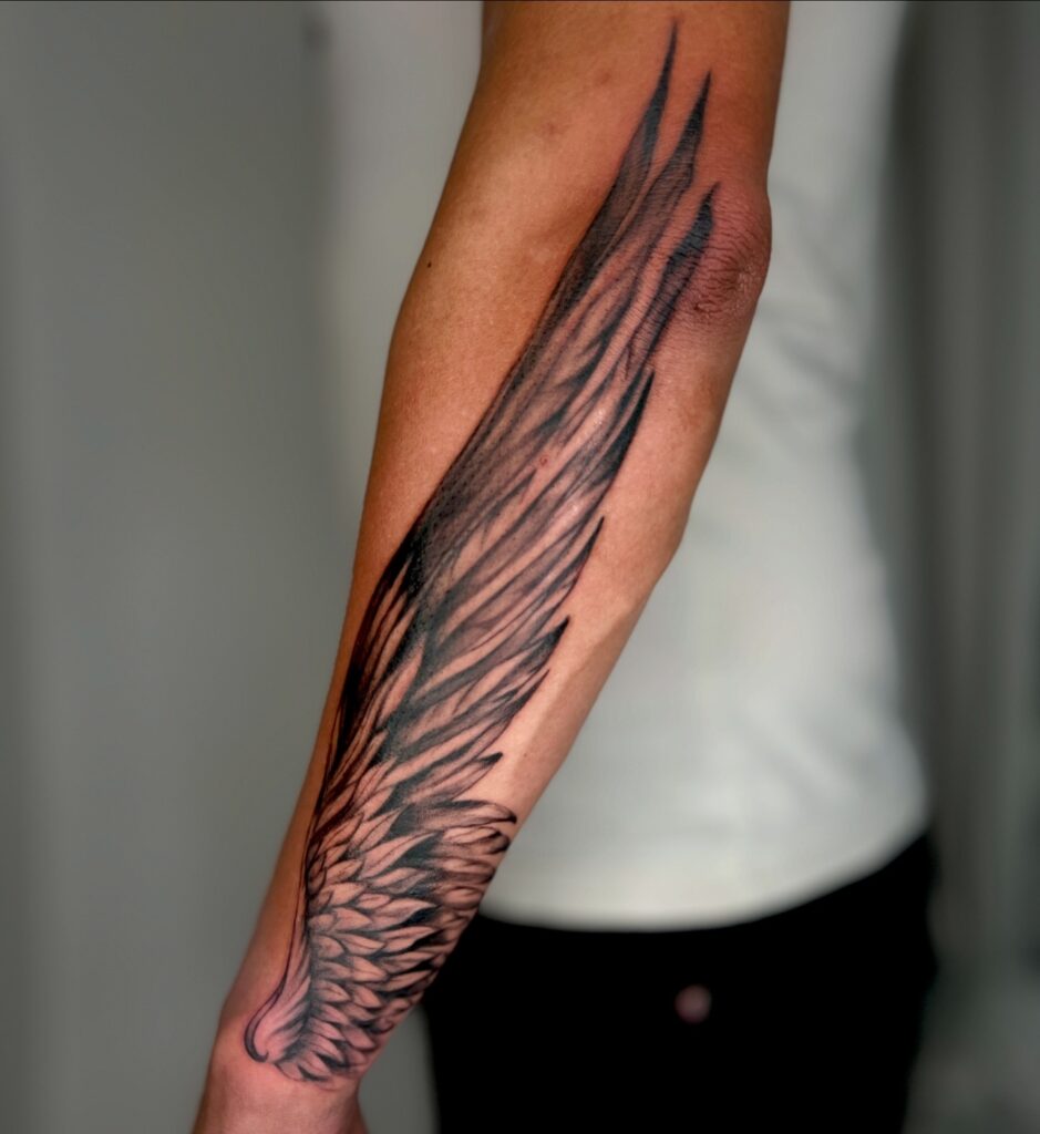Full-Length Angel Wing Forearm Tattoo angel wings tattoo ideas tattoo