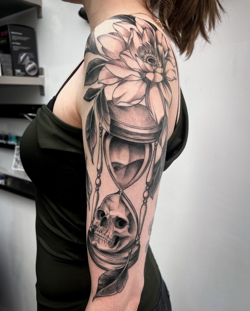 Hourglass and Skull Half-Sleeve Tattoo with Flowers hourglass tattoo ideas tattoo