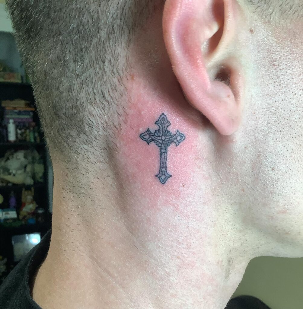 Intricate gothic cross behind the ear tattoo
