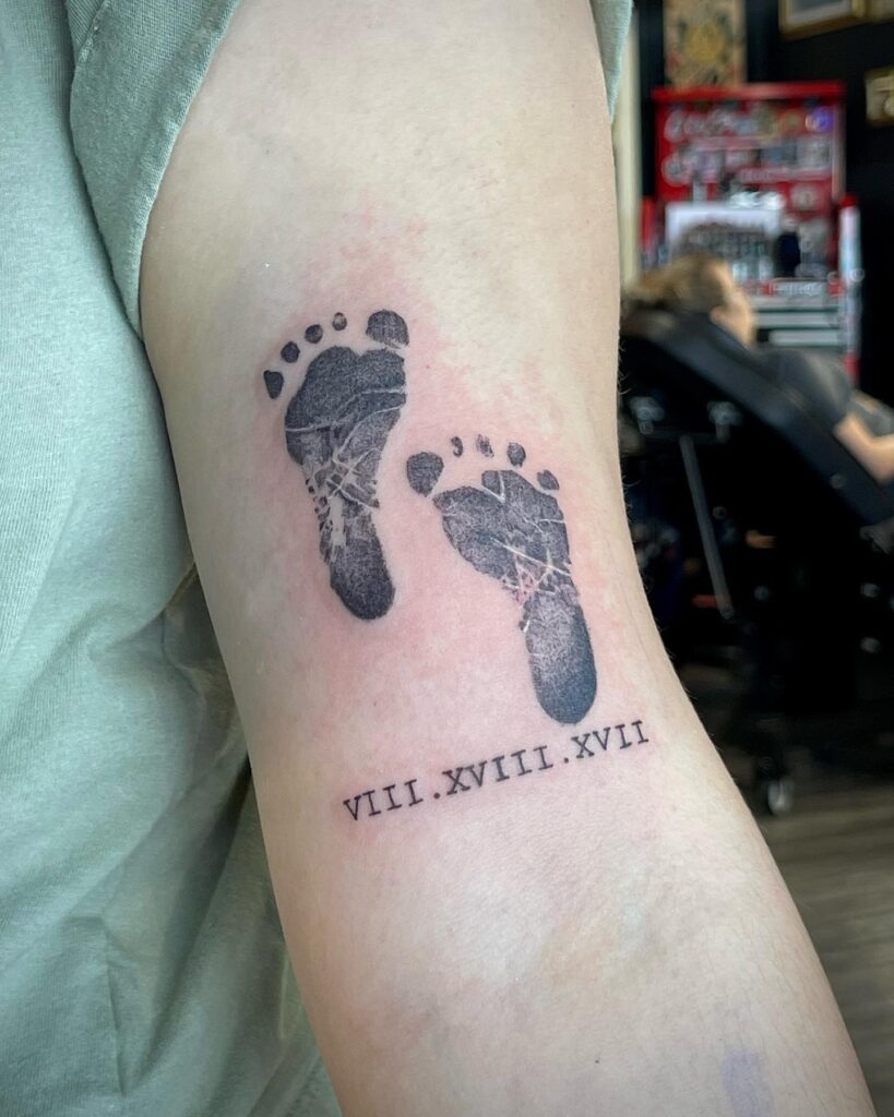 Minimalist Baby Footprints with Roman Numerals Tattoo baby feet tattoos tattoo