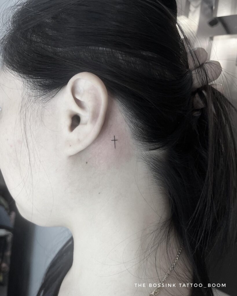 Minimalist cross behind the ear tattoo