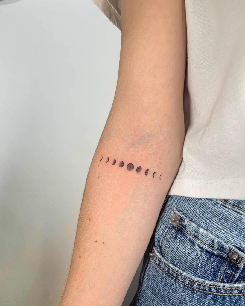 Horizontal moon phases arm tattoo