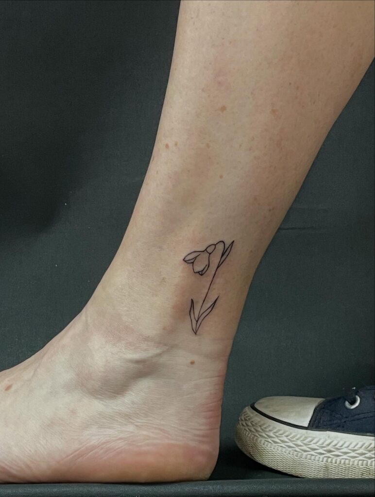 Small snowdrop flower tattoo on the ankle