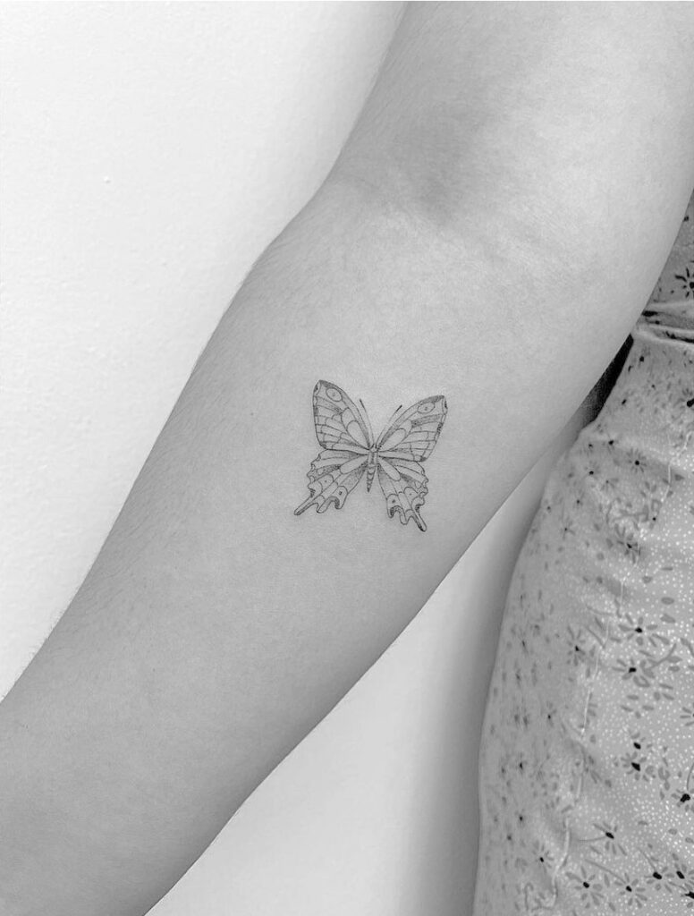 Fine line monarch butterfly tattoo on forearm