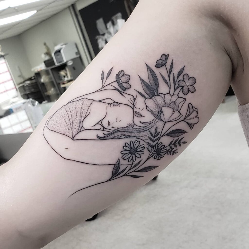 Mother Embracing Sleeping Baby with Flowers Tattoo mommy tattoo ideas tattoo