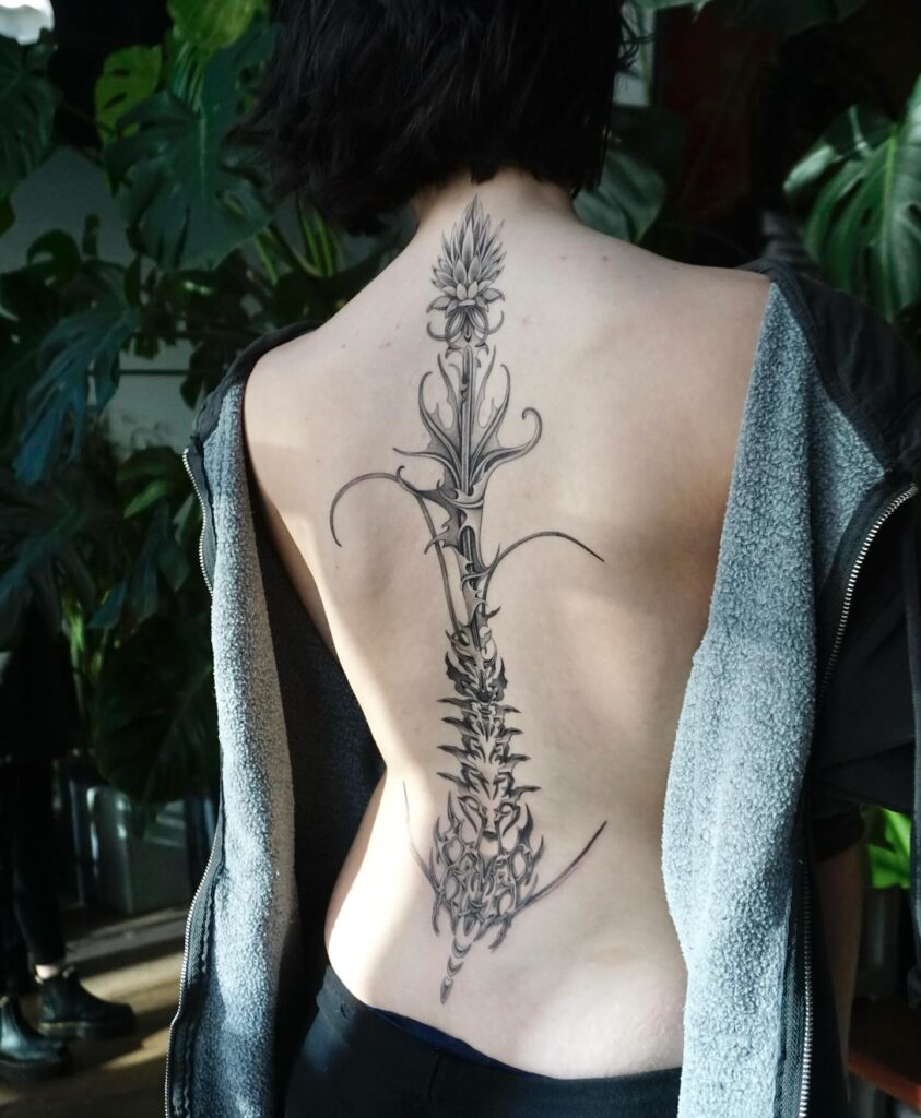Minimalist Lotus And Sun Spine Tattoo