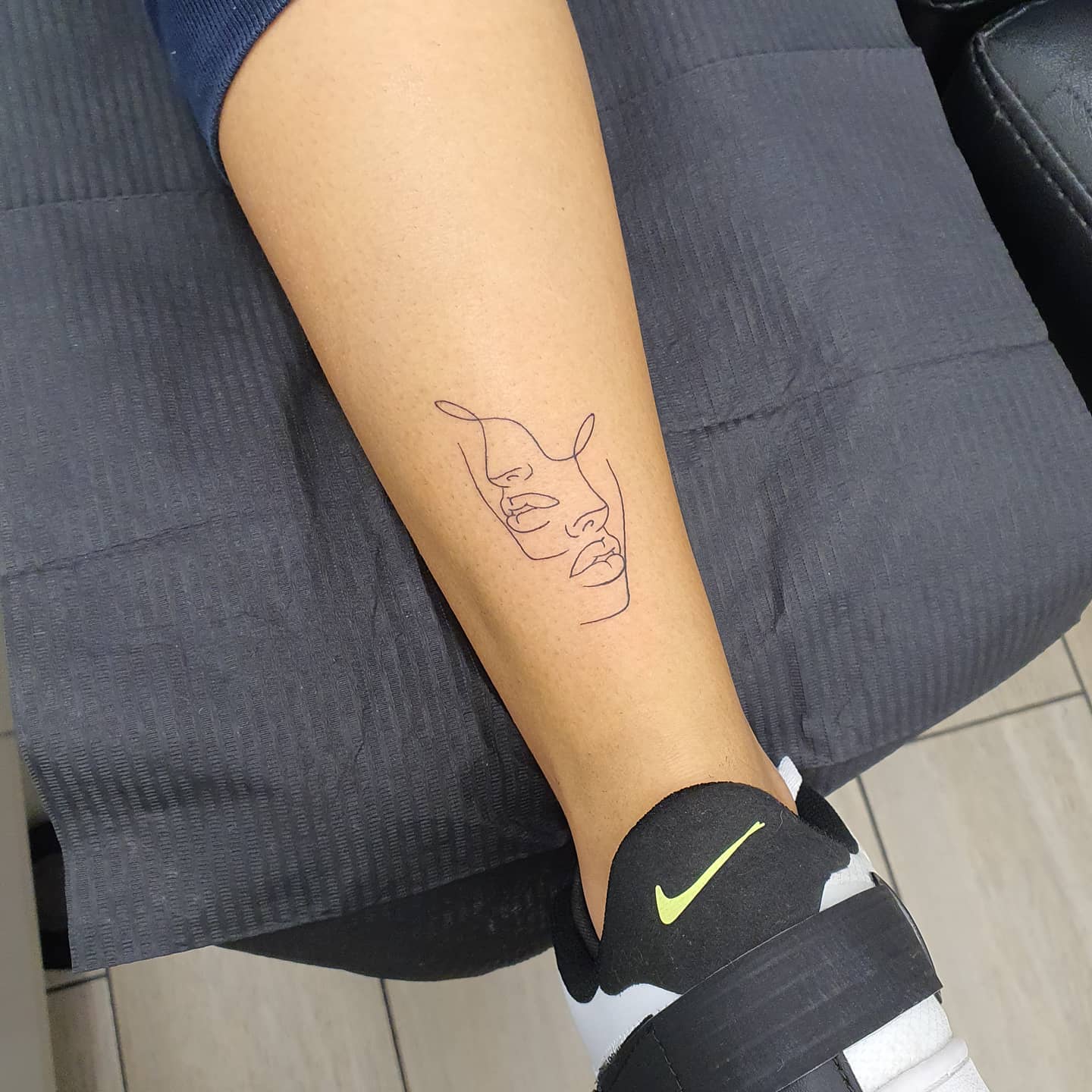 One line overlapping faces tattoo with modernist aesthetic