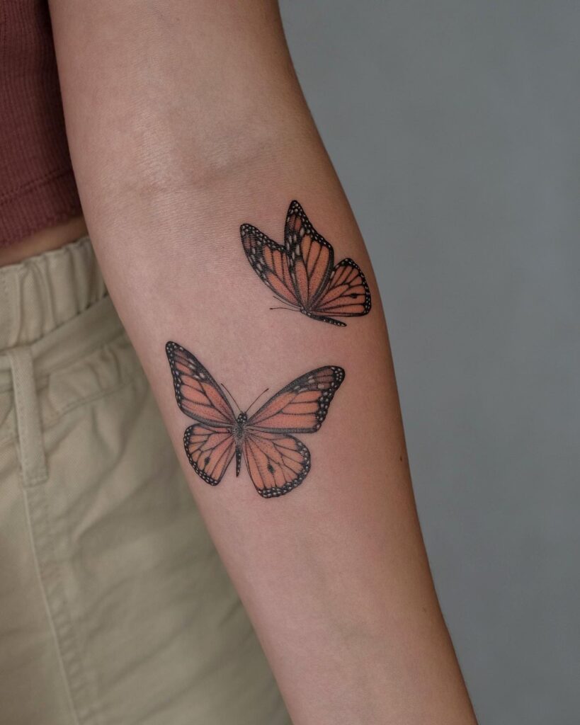 Two monarch butterfly tattoos on forearm