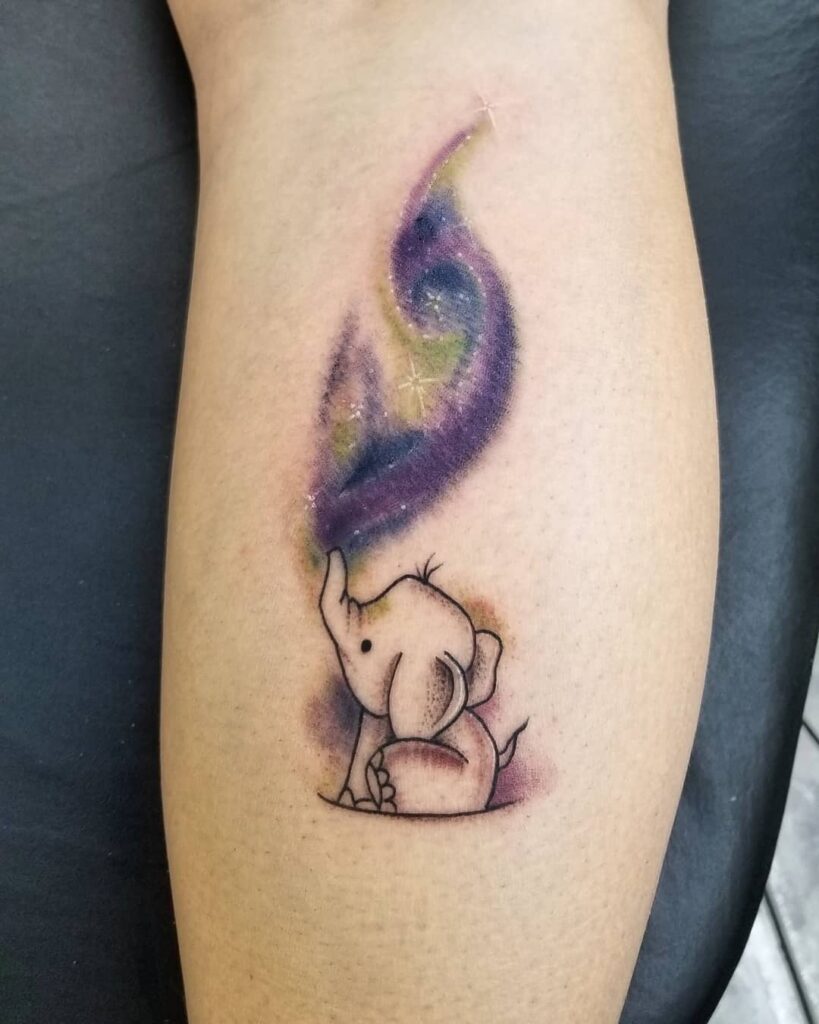 Playful baby elephant tattoo with cosmic swirl