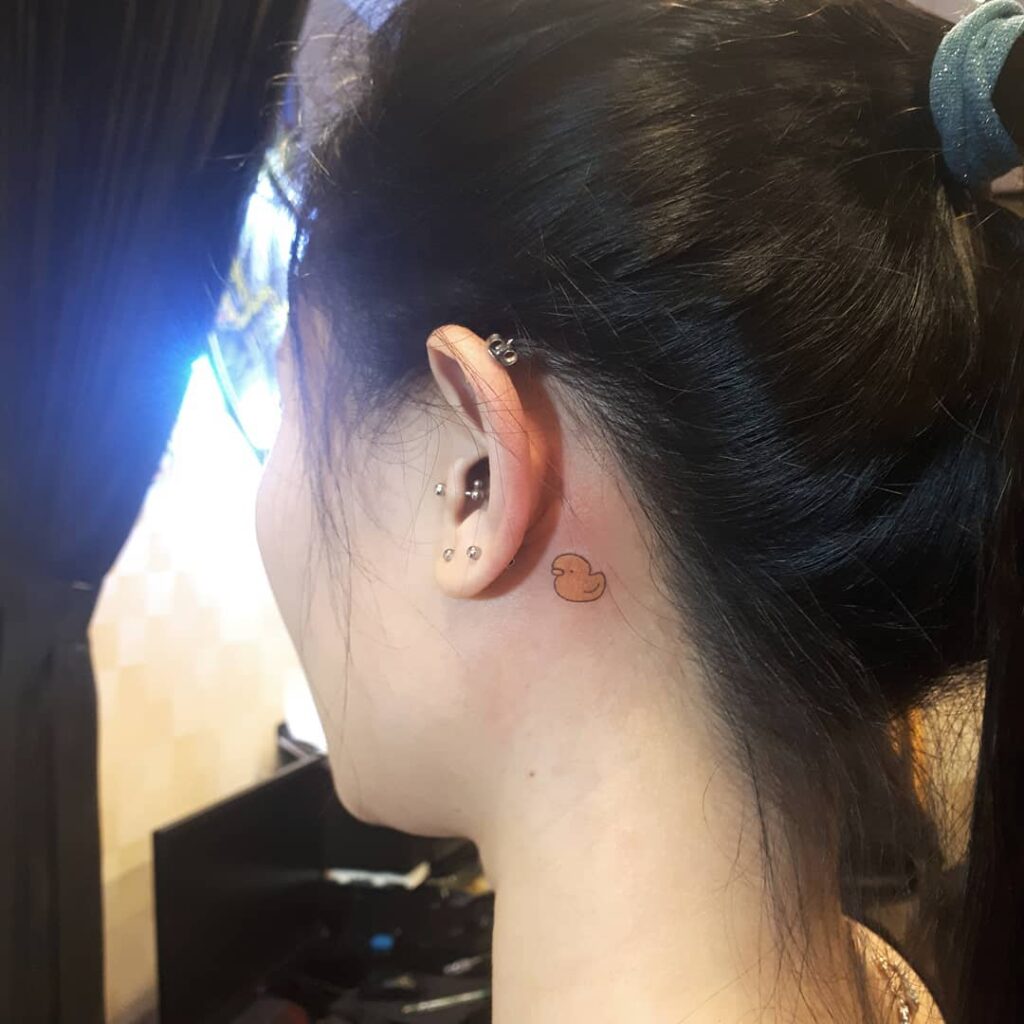 Mini Triceratops Behind Ear Tattoo