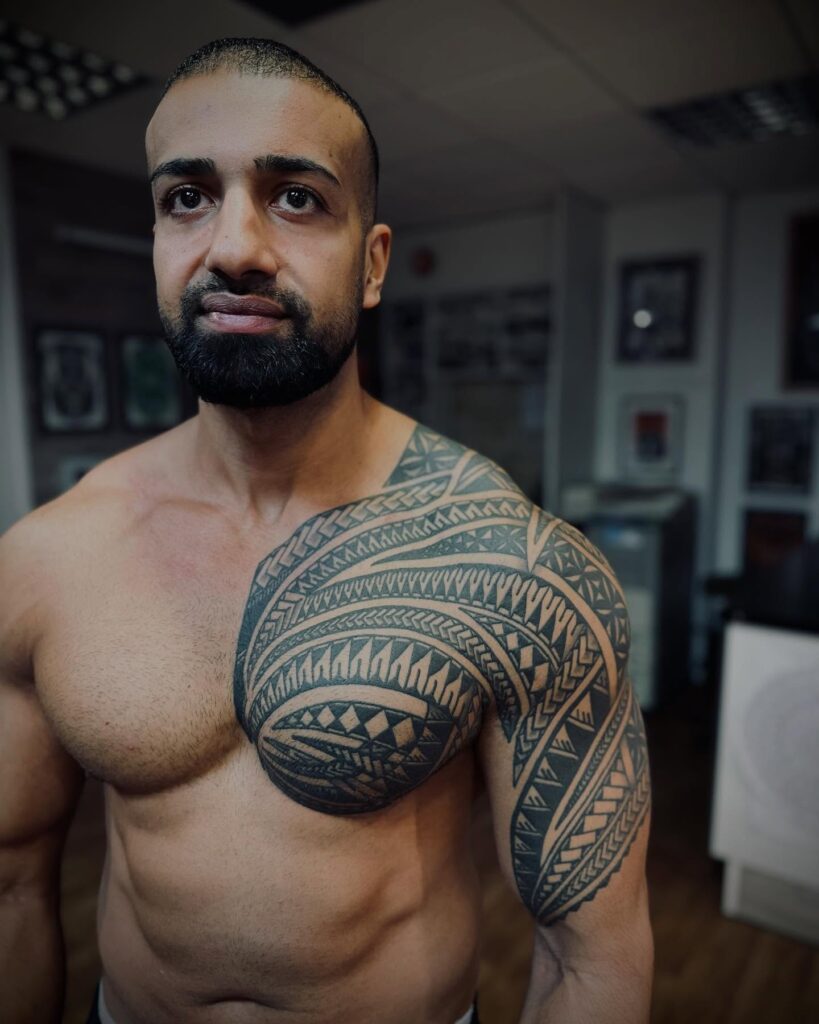 Ornamental Tribal Neck And Chest Tattoo