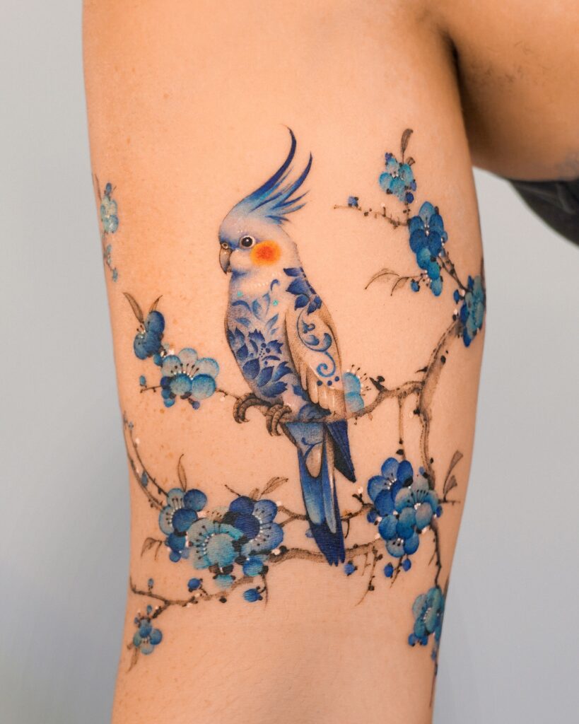 Porcelain Cockatiel on Floral Brushstroke Branches Tattoo bird tattoo ideas for women with meaning tattoo