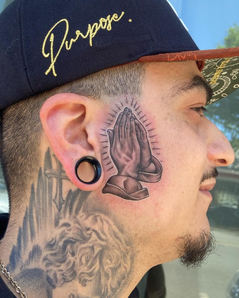 Praying Hands with Radiant Lines Face Tattoo praying hands tattoos tattoo
