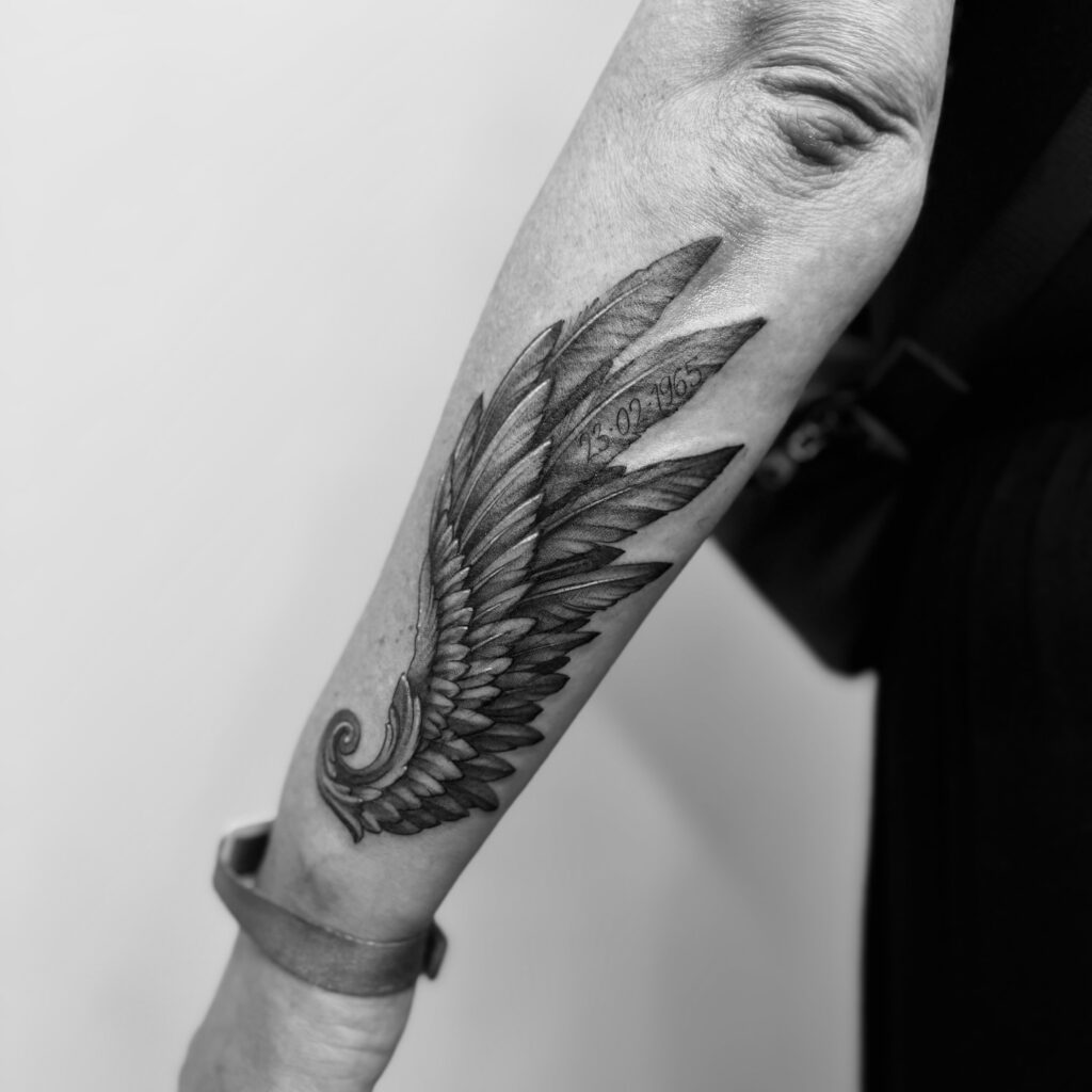 Realistic Angel Wing Forearm Tattoo with Birthdate angel wings tattoo ideas tattoo