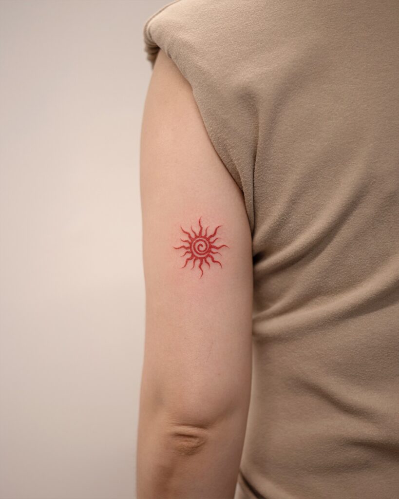 Red Spiral Sun Tattoo on Upper Arm sun tattoos tattoo