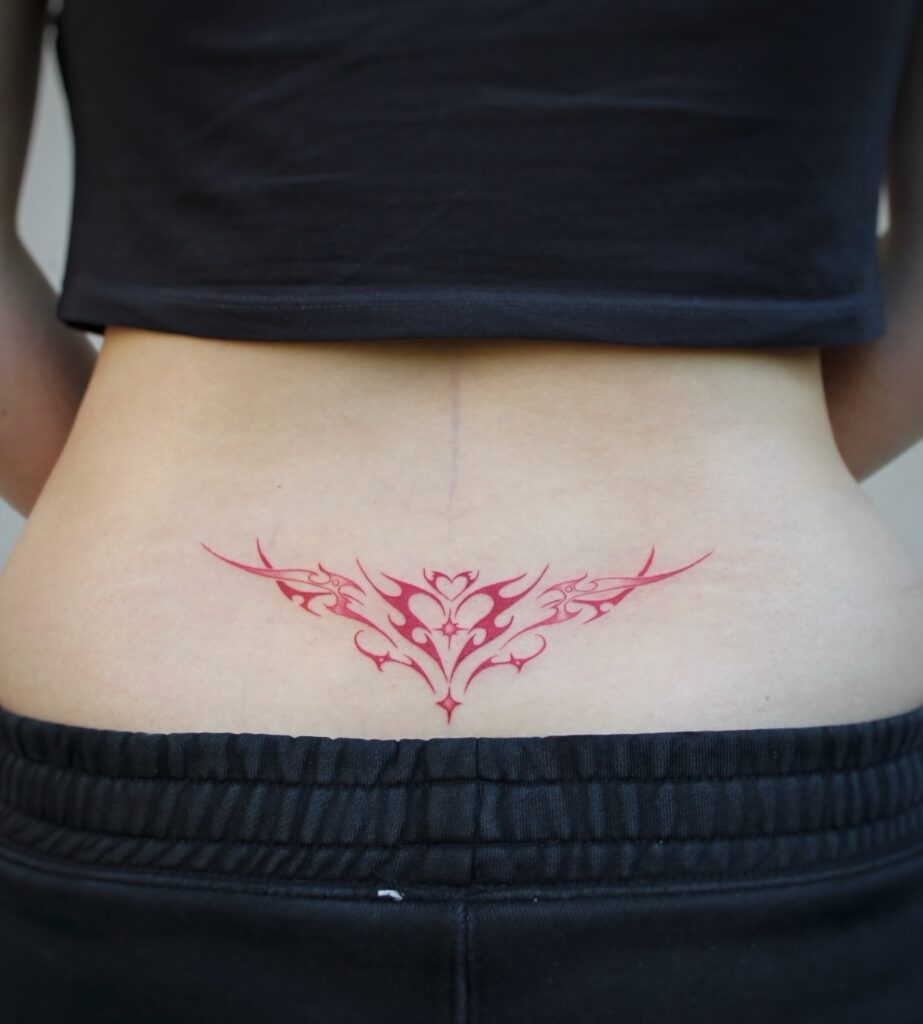 Tribal Butterfly In Red And Black Lower Back Tattoo