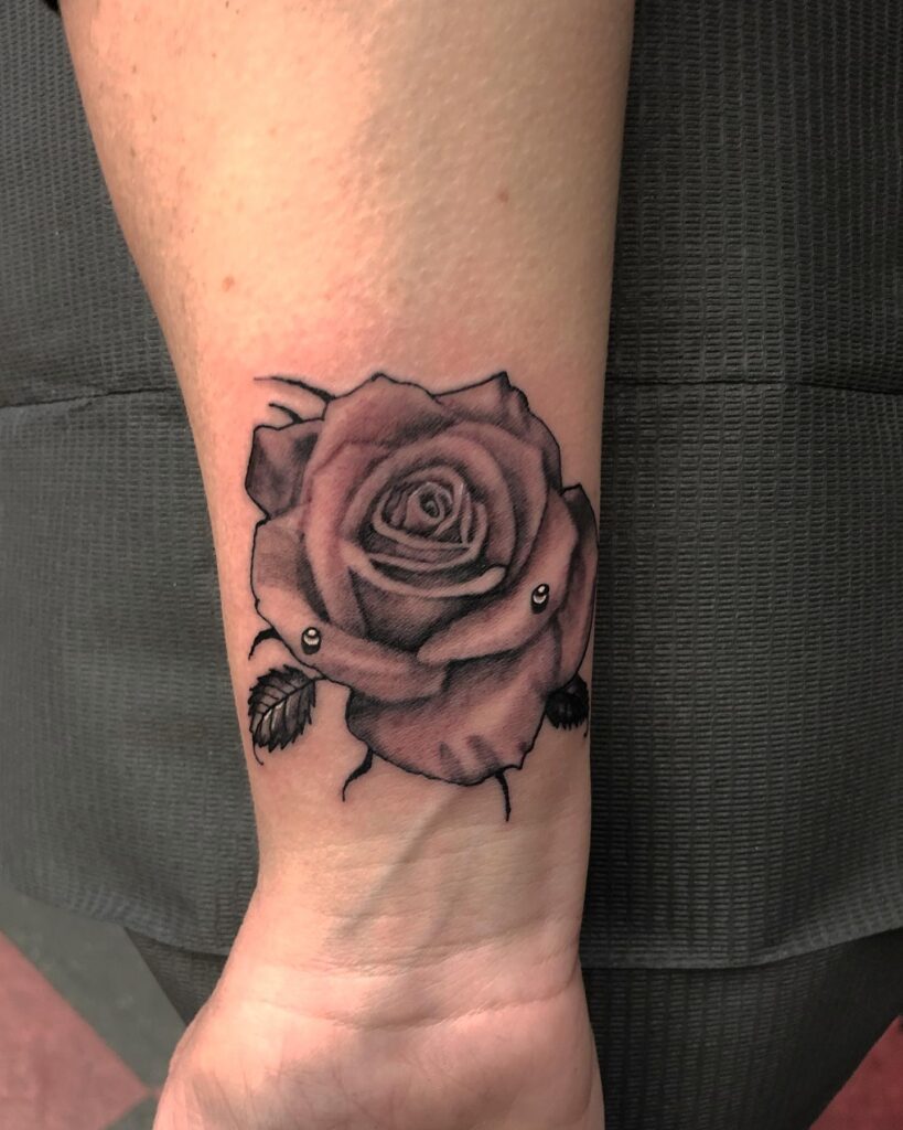Shaded Rose Wrist Tattoo with Piercing Accents flower wrist tattoo ideas tattoo