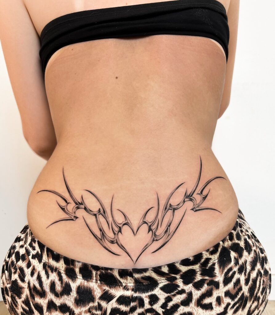 Tribal Heart With Stars Lower Back Tattoo